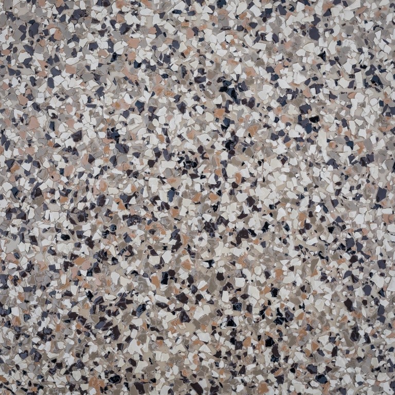 This is a close-up image of a speckled terrazzo floor with a variety of neutral toned chips embedded in a solid matrix.