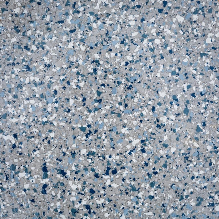 This image shows a terrazzo flooring sample with a random pattern of blue, white, and grey fragments set within a polished material.