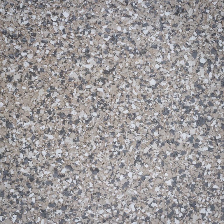 This is a close-up image of a terrazzo floor, showing a speckled pattern of marble chips in varying shades of gray, white, and black.