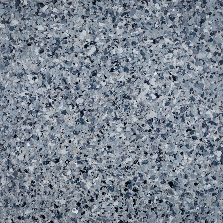This is a close-up image of a terrazzo surface, showcasing a speckled pattern of grey, white, and black chips scattered consistently throughout.