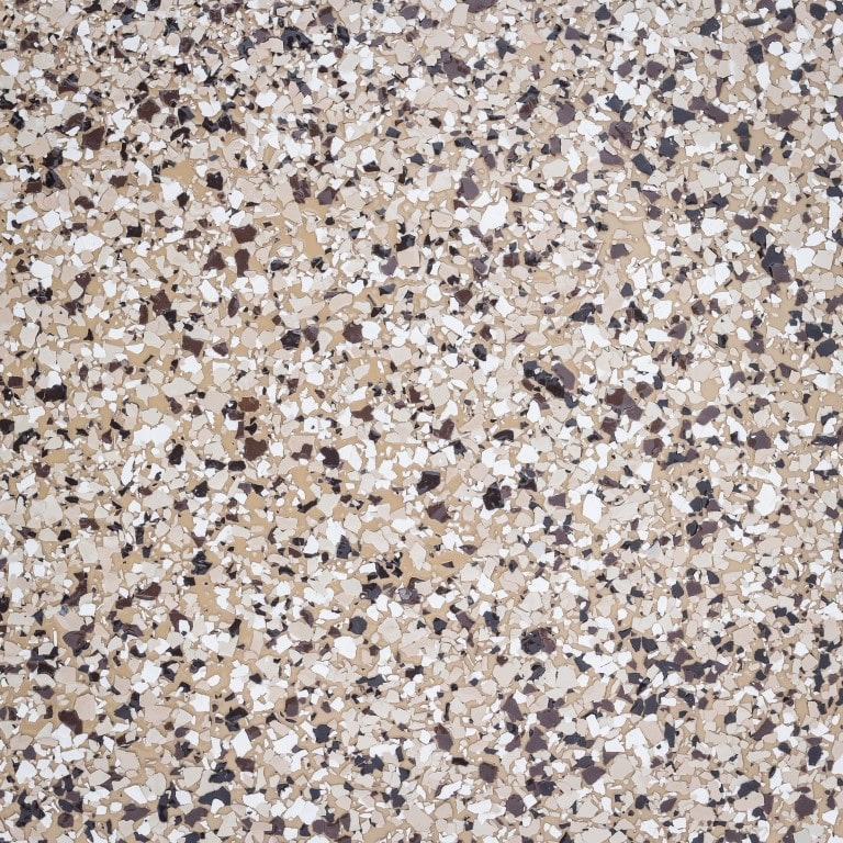 The image shows a close-up of a terrazzo floor with a speckled pattern of variously sized brown, white, and black fragments dispersed evenly across the surface.