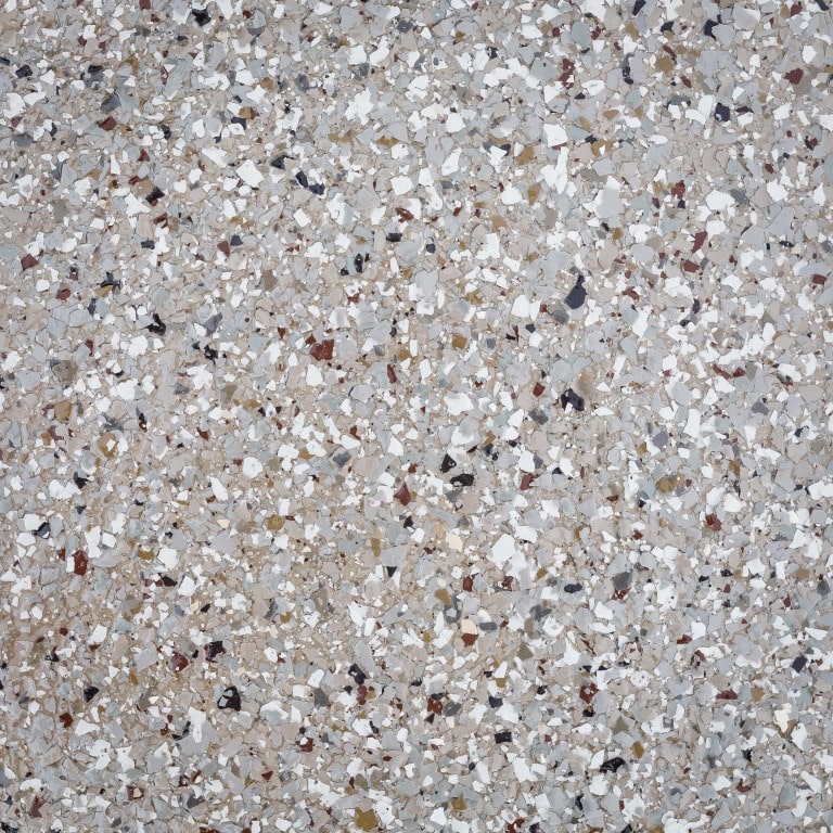 This image shows a close-up texture of terrazzo flooring with various colored chips scattered throughout a light gray base material.